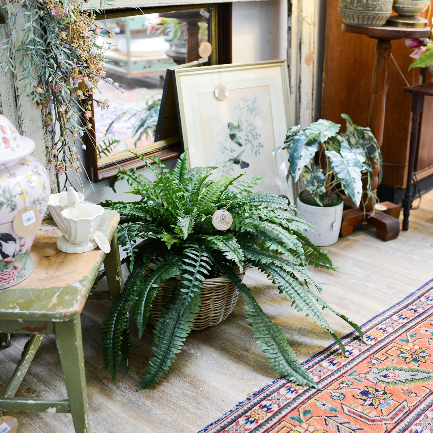 Decorative room with a fireplace, plants, antiques, and a colorful rug at Branches Hilton Head Island, South Carolina.