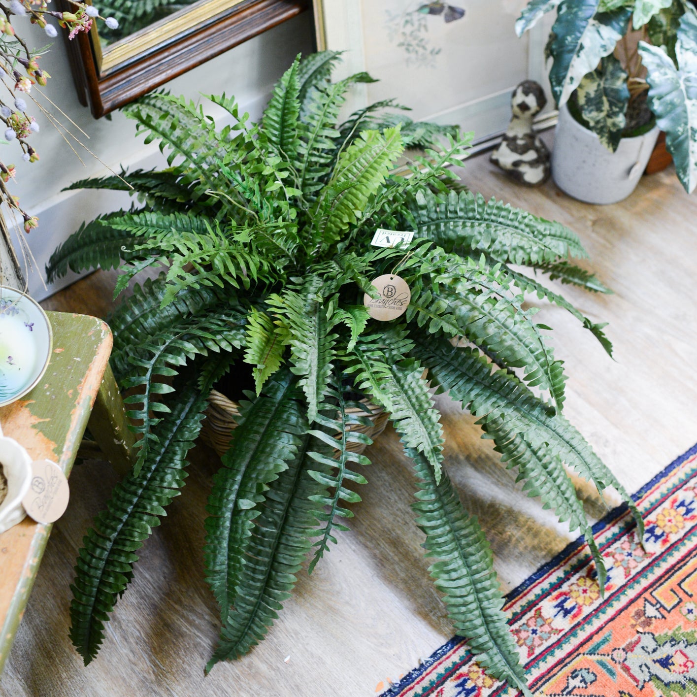 Decorative room with a fireplace, plants, antiques, and a colorful rug at Branches Hilton Head Island, South Carolina.
